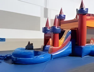 Inflatable bounce house and slide with a castle theme, set up outdoors.